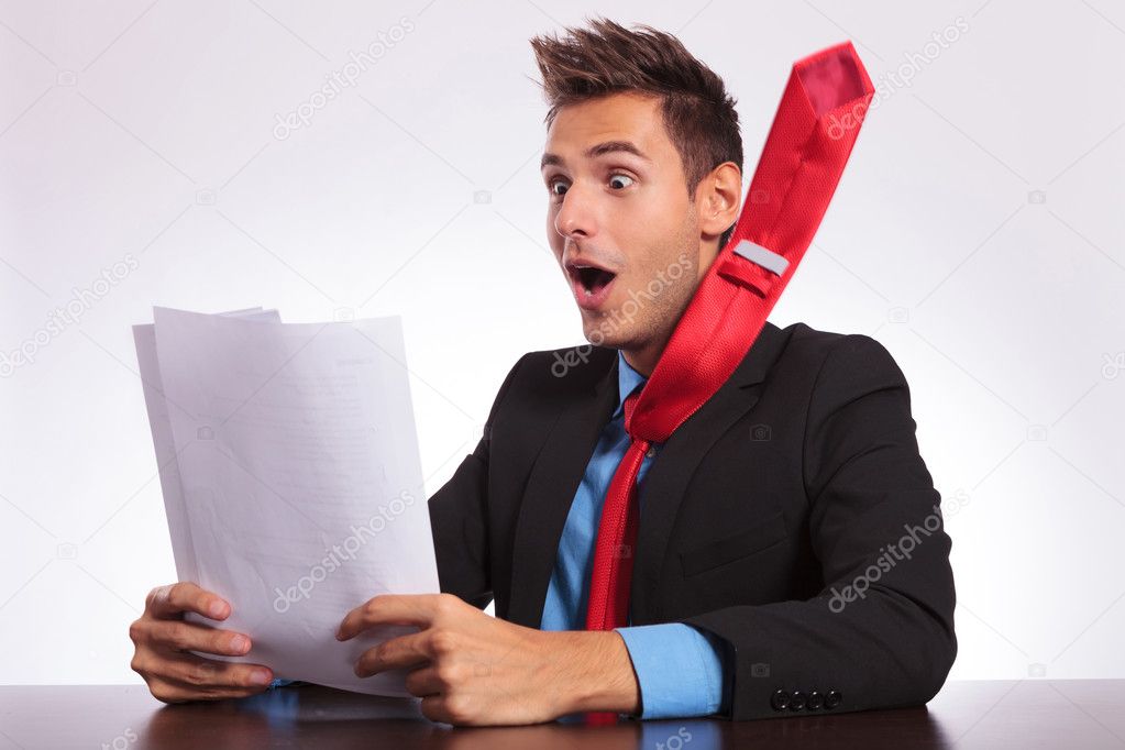 man at desk reads spectacular news