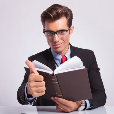 kitap ve başparmak tabela holding