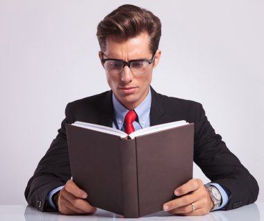 iş adamı onun masasında kitap okumak