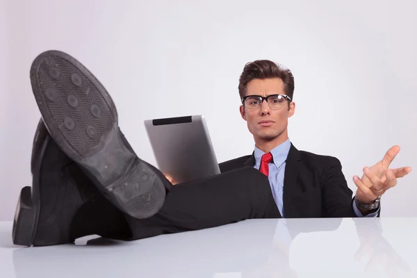 Hombre de negocios piernas en escritorio celebración tableta —  Fotos de Stock