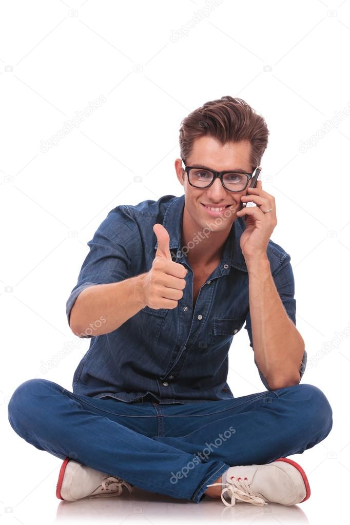 seated man on the phone ok sign