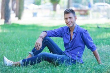 park gülümseyerek oturan adam