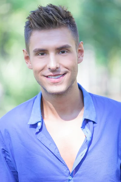 Young man smiles outdoors — Stock Photo, Image