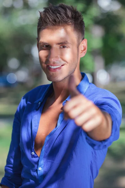 Sonriente hombre en parque mostrando ok — Foto de Stock