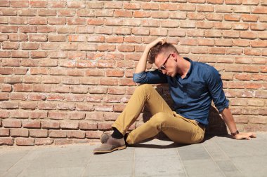 casual man sits upset by wall clipart