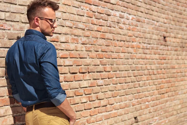 Casual man by wall back view — Stock Photo, Image