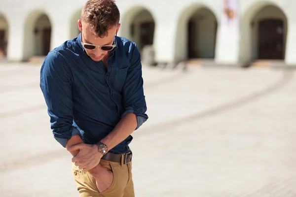 Casual man reaching into pocket — Stock Photo, Image