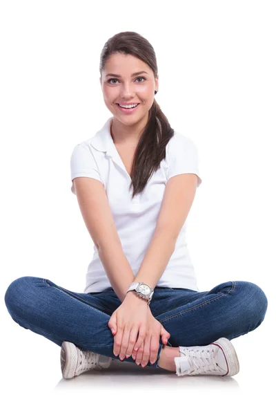 Casual woman holds crossed legs — Stock Photo, Image