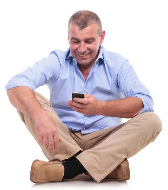 Casual yaşlı adam oturur ve telefonu çalar