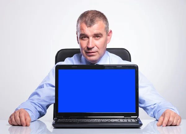 Viejo hombre de negocios en el escritorio con la computadora portátil de pantalla vacía — Foto de Stock