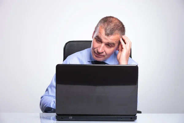 Old business man looks puzzled at laptop — Stock Photo, Image