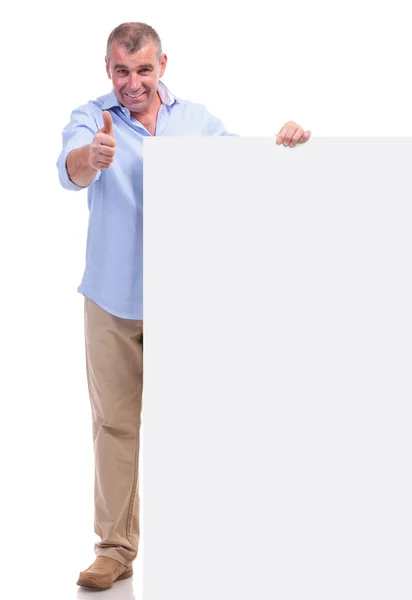 Casual middle aged man shows ok by pannel — Stockfoto