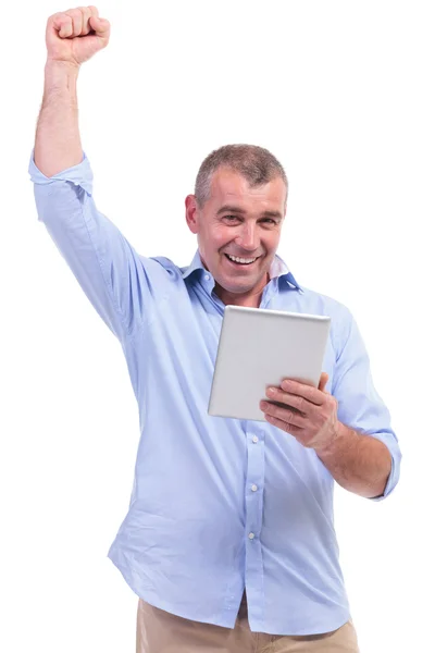 Casual middle aged man cheering with pad — Stock Photo, Image