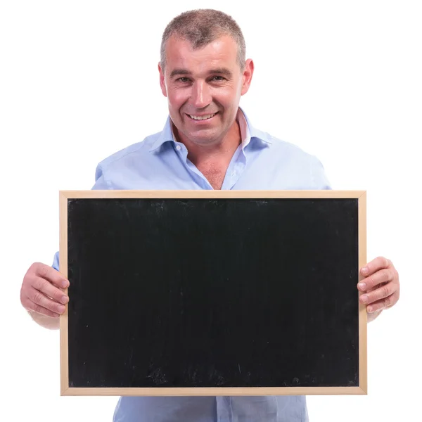 Casual old man holds a blank blackboard — Stock Photo, Image