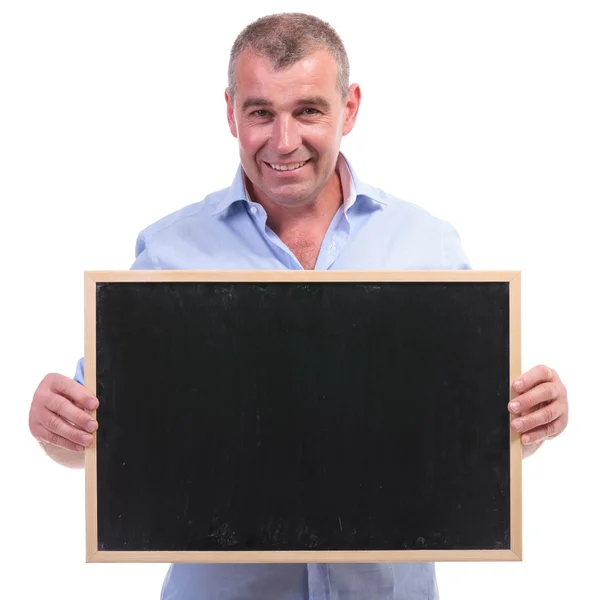 Homem velho casual detém um quadro negro em branco — Fotografia de Stock