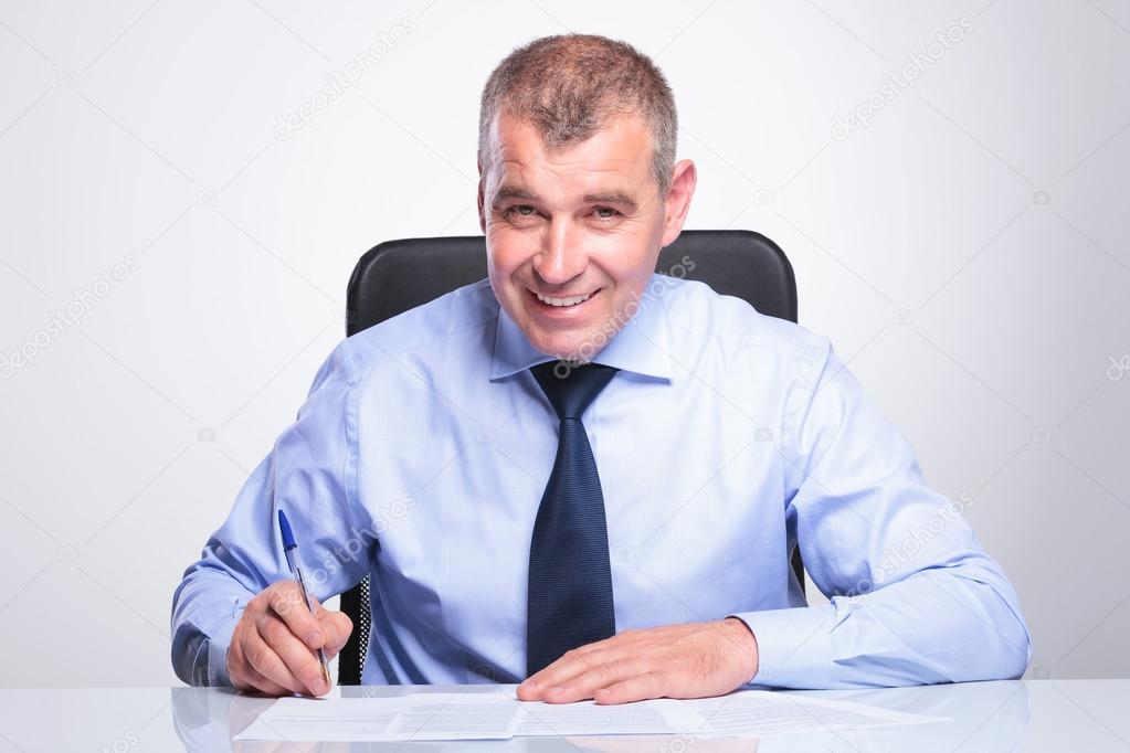 old business man signs contracts at desk