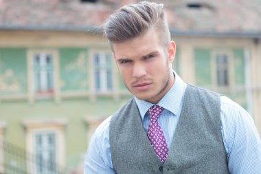 Casual adam kravat ve yelek bakıyor