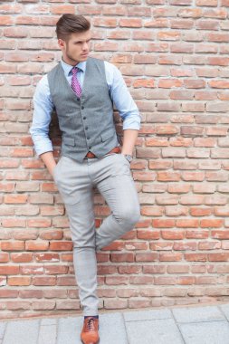 Casual adam duvara eğilir ve uzak görünüyor