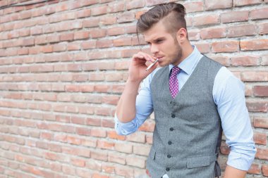 Casual adam sigara ağız açık tutar.