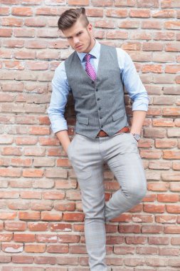 Casual adam elleri ceplerinde, tuğla duvar