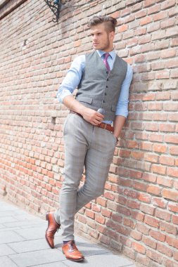 Casual adam tuğla duvarın duruyor