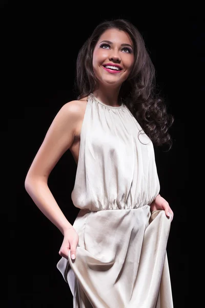 Schoonheid vrouw houdt haar jurk met beide handen — Stockfoto