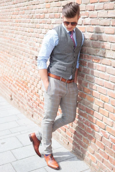 Casual man leans on wall and looks down — Stock Photo, Image