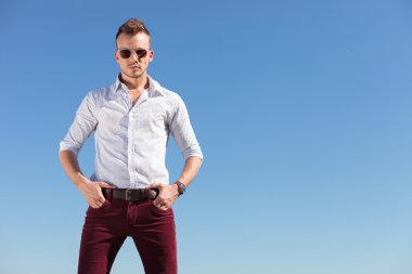 Casual adam elleri cebinde önünde mavi gökyüzü