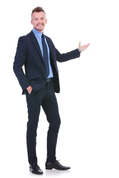 Business man presents with hand in pocket — Stock Photo, Image