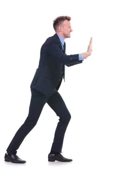 Business man pushes imaginary wall — Stock Photo, Image