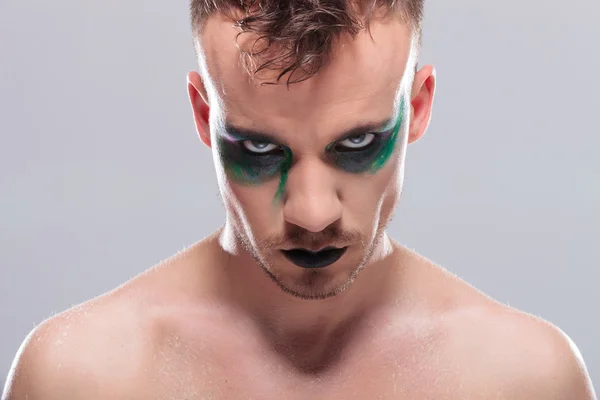 Lässiger Mann mit Make-up sieht einen emotionslos an — Stockfoto