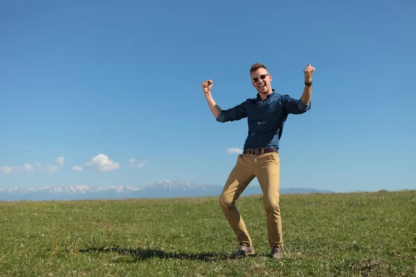Homem casual ao ar livre aplausos em uma planície verde — Fotografia de Stock