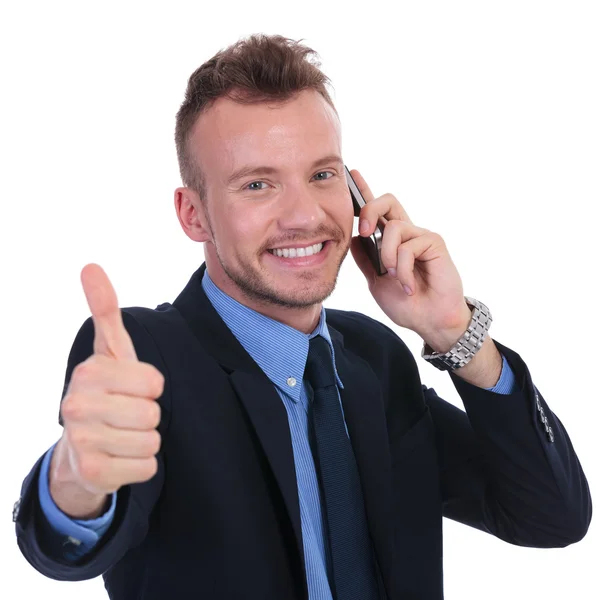 Business man shows thumb up while on phone Stock Image