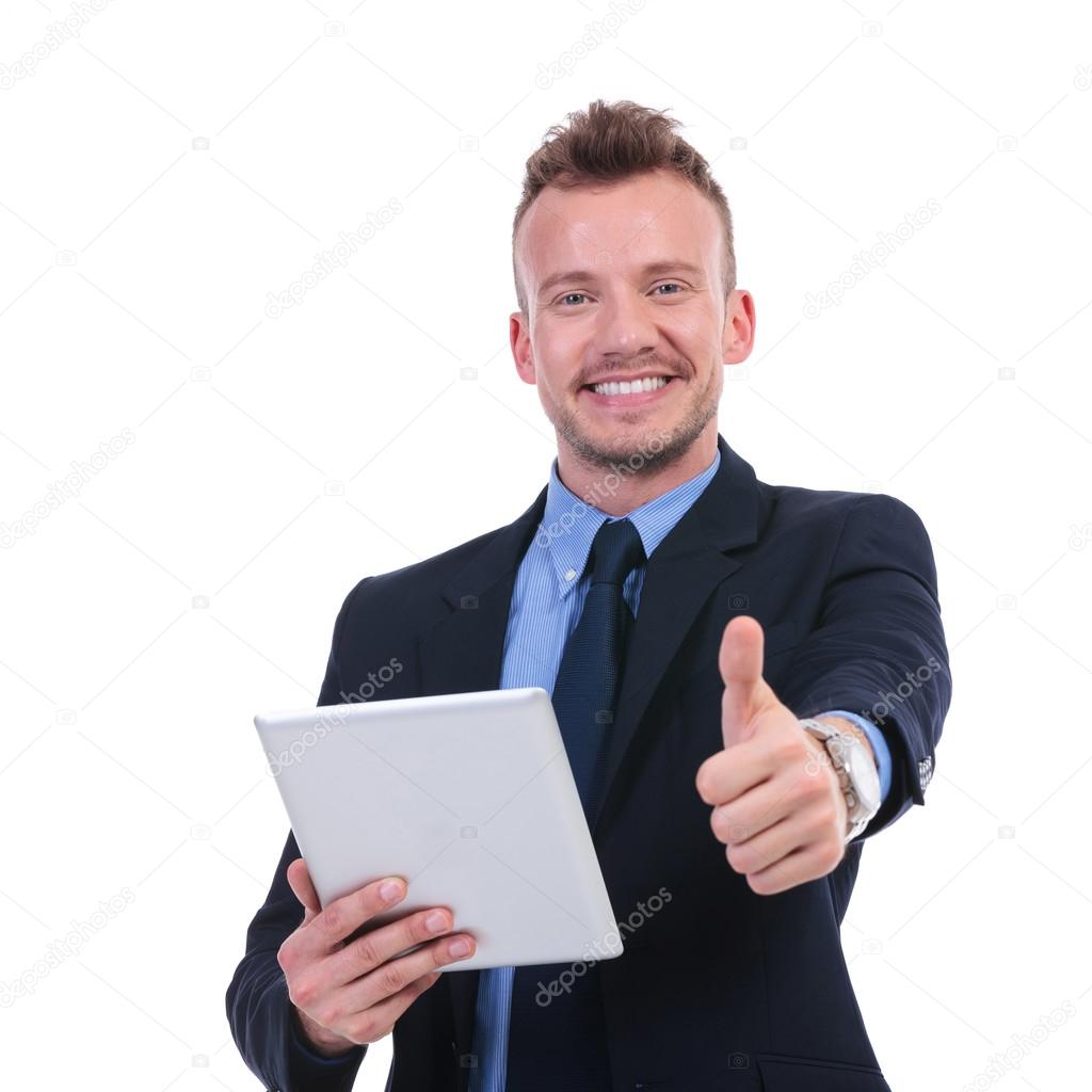 business man holds tablet and shows thumb up
