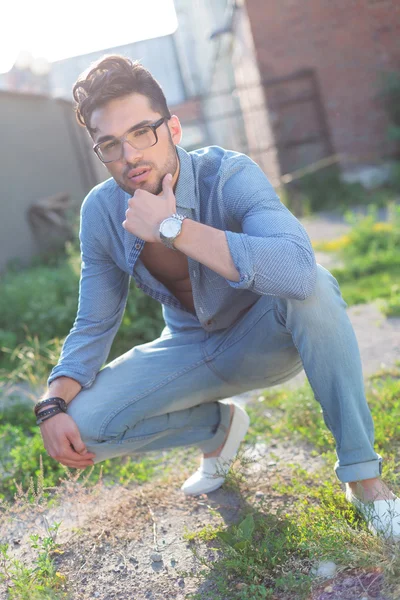 Pensive casual man sits crouched — Stock Photo, Image