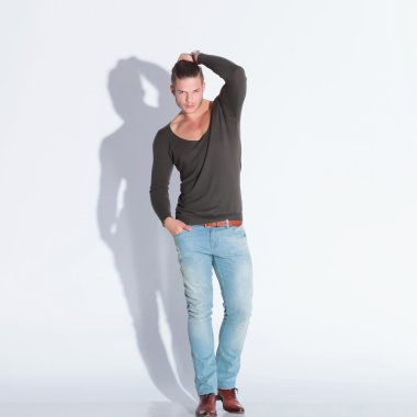 Casual adam elini saçında tutar.