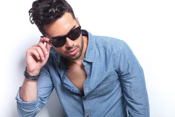 Casual man with hand on sunglasses — Stock Photo, Image