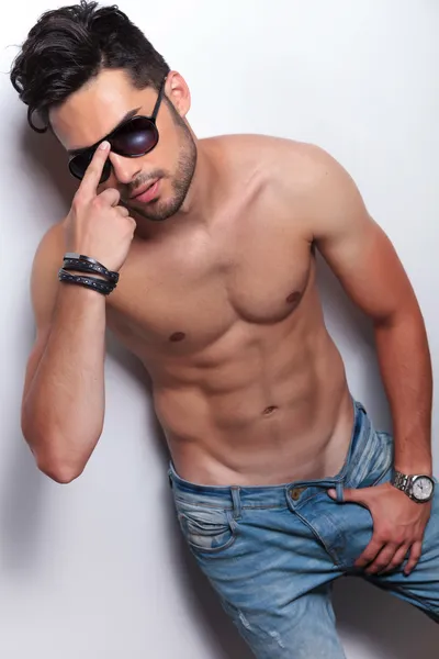 Jeune homme seins nus ajuste ses lunettes de soleil — Photo