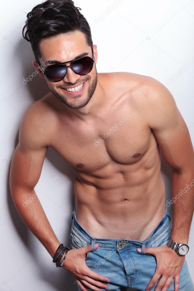 topless young man smiles at you