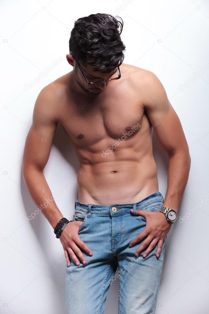 topless young man looks down