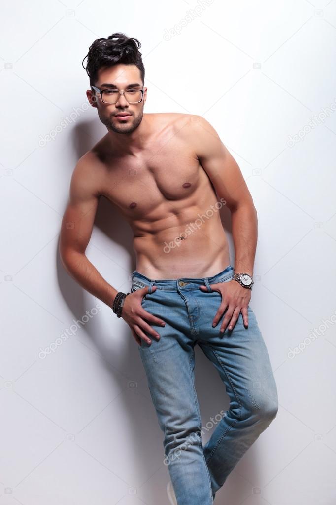 topless young man stands with thumbs in loops