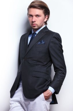 iş adamı elleri ceplerinde duvara yaslanmış