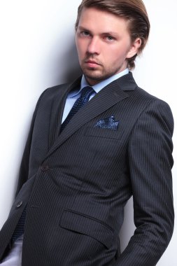 iş adamı elleri ceplerinde duvara eğilir.