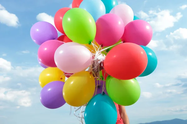 Bunch of balloons held by a man outdoor — Stock Photo, Image