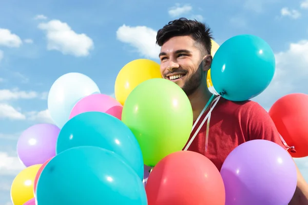 Homem casual com balões por todo o lado — Fotografia de Stock