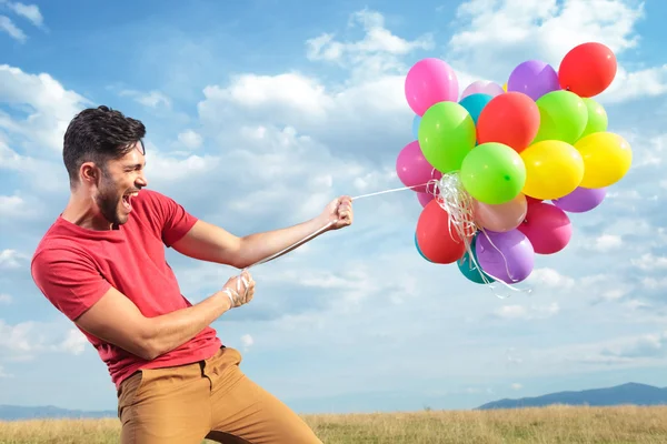 Casual man med färgglada ballonger — Stockfoto