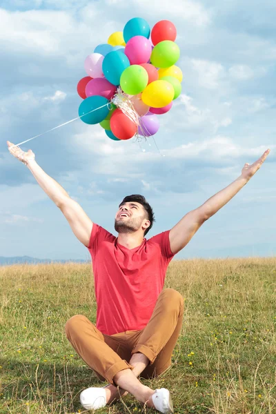 Homme décontracté tient des ballons à bras ouverts — Photo