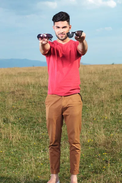 Casual man presenterar två typer av solglasögon — Stockfoto