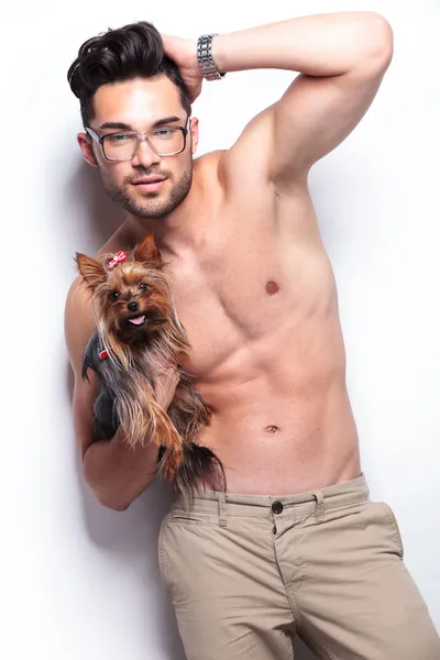 Topless giovane uomo tiene cucciolo mentre posa — Foto Stock