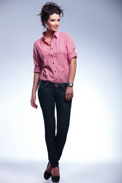 Mujer joven casual en jeans y camisa roja mirando hacia otro lado —  Fotos de Stock